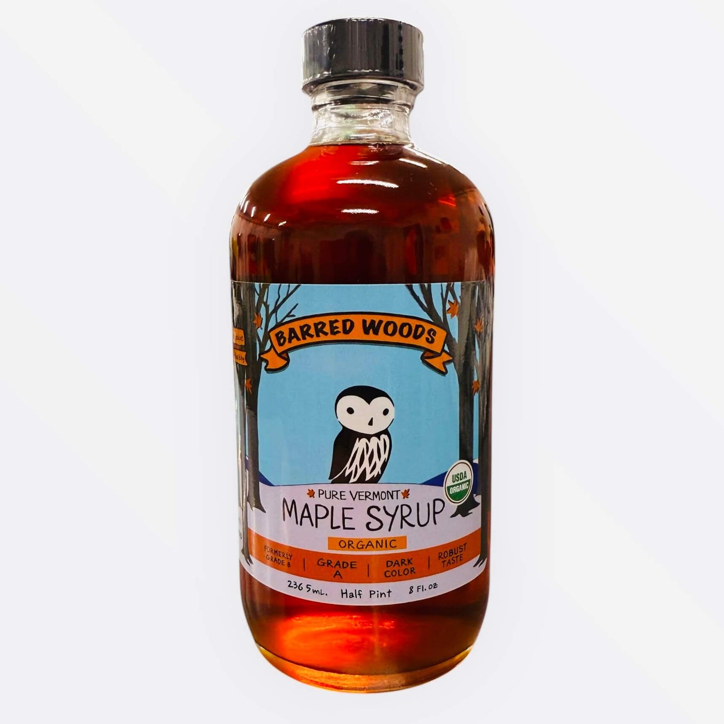 A glass bottle of grade b  maple syrup produced by Barred Woods Maple.