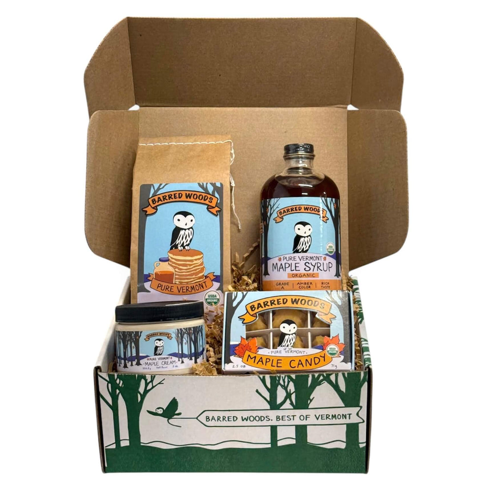 Gift Box of Barred Woods maple syrup products including pure Vermont maple syrup, maple candy, and maple cream on a white background.