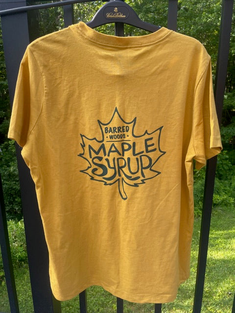 Back of a yellow t-shirt with 'Barred Woods Maple Syrup' logo on a hanger outdoors.